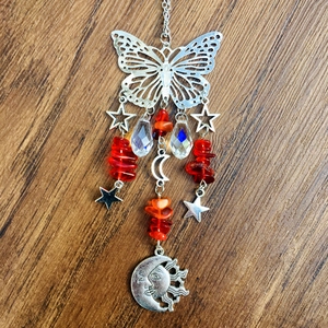 Detail of silver suncatcher featuring a metal butterfly, moon, and crystal beads