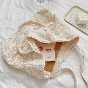 Detailed view of cream lace canvas tote bag with woven patterns and floral hollow texture