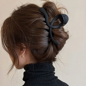 Pince à cheveux cœur noire mate élégante présentée sur les cheveux d'un mannequin