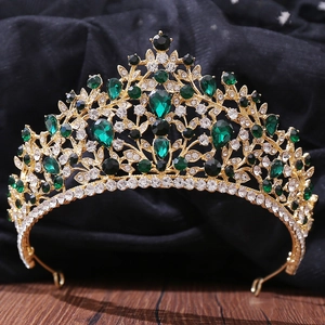 Macro detail of luxury bridal crown featuring emerald stones and intricate gold filigree