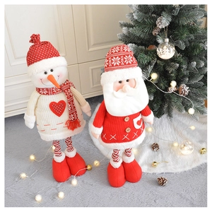 Close-up of plush Christmas snowman and Santa dolls with knitted details and striped legs
