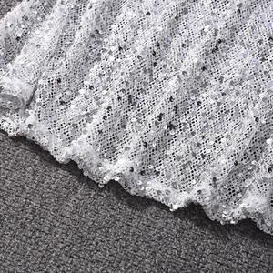 Gros plan détaillé de paillettes argentées sur tissu en maille pour robe de soirée