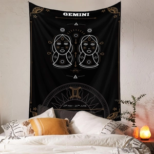 Detail of black Gemini zodiac tapestry hanging above a bed for bohemian room decor