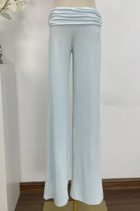 Detailed view of light blue knit wide-leg pants with rhinestone G logo and elastic waist