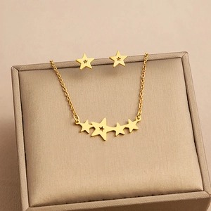 Detail of gold star jewelry set with layered necklace and matching stud earrings