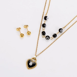Detail of gold double-layer necklace with devil eye heart pendant and matching ball earrings