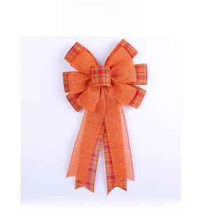 Detail of harvest pumpkin orange bow with plaid edges for autumn holiday decor