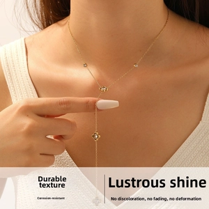 Detail of a gold-plated stainless steel Y-shaped necklace with flower charms and diamonds