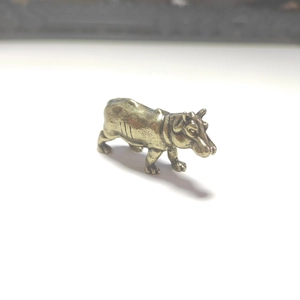 Macro detail of solid brass hippo figurine showing vintage texture and skin details