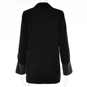 Vista posteriore dettagliata di un blazer nero con polsini decorati da strass lucidi