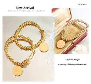 Detail of 18K gold beaded stretch bracelet featuring an engraved round charm