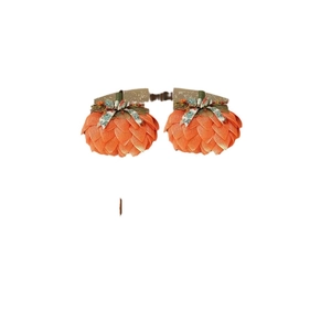 Pair of orange fabric pumpkin hair clips with green leaf details for Halloween decor