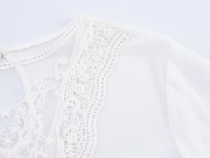 Detailed close-up of lace patchwork and hollow embroidery on a white chiffon blouse