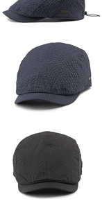 Detail of water-resistant seersucker flat cap with adjustable cord and metal badge
