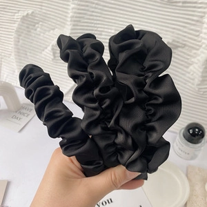 Detail showing the pleated fabric texture and craftsmanship of the black headband