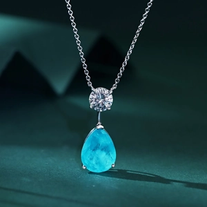 Macro shot of 925 silver necklace with pear-cut Paraiba tourmaline and zircon pendant