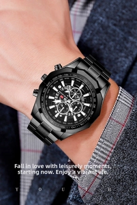 Men's chronograph watch with black steel band worn under a dark business suit sleeve