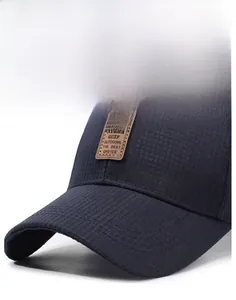 Detailed close-up of navy baseball cap with knit texture and brown leather logo patch