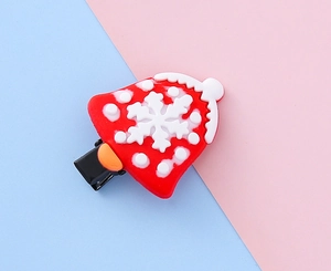Gros plan sur la pince à cheveux de Noël rouge en forme de cloche avec flocons de neige