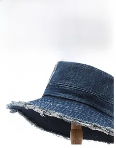 Close-up of distressed fringe brim on vintage navy blue washed denim bucket hat