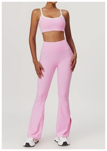 Pink yoga set featuring sports bra with white straps and split hem flare leggings