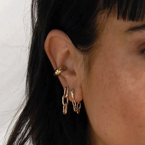 Macro shot of gold plated silver snake chain earrings with moon star diamond studs on ear