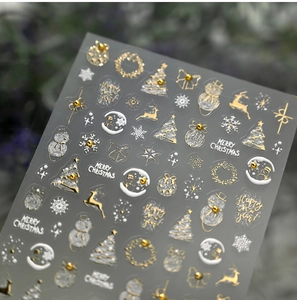 Makro-Details von Weihnachts-Nagelaufklebern mit goldenen Rentier- und Schneeflockenmotiven