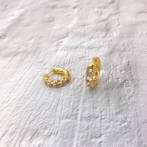 Close-up of 18K gold plated hoop earrings with five clear cubic zirconia stones