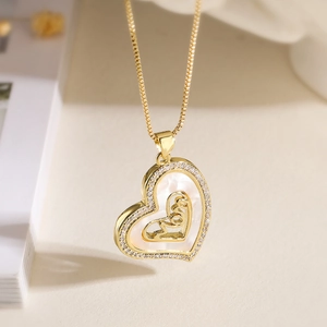 Gold plated heart necklace with zircon and shell inlay on a soft blurred background