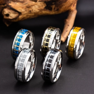 Detail of colorful cross patterned titanium steel rings in blue gold and silver