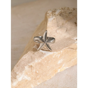 Polished silver starfish stainless steel ring displayed on a natural rock surface