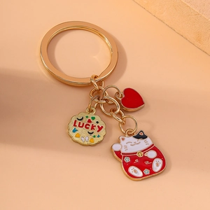 Lucky cat keychain with red heart and gold pendant on orange background