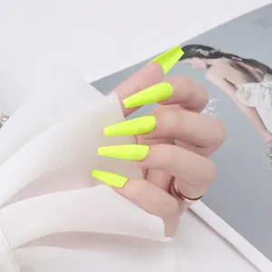 Faux ongles cercueil extra longs jaune fluo mat présentés sur main avec du filet