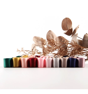 Close-up of colorful 1.5cm double-sided satin ribbons neatly rolled for gift packaging