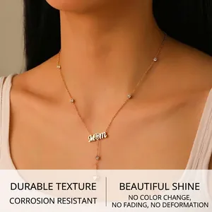 Détail du collier pendentif MOM doré avec cœur et frange en Y sur un mannequin femme