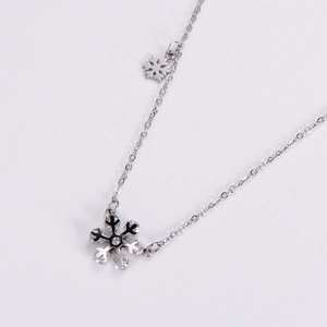 Silver snowflake necklace with sparkling stones on minimalist chain shown from a top angle