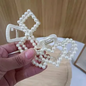 Elegant large pearl claw clip set with white faux pearls on a metal base for women