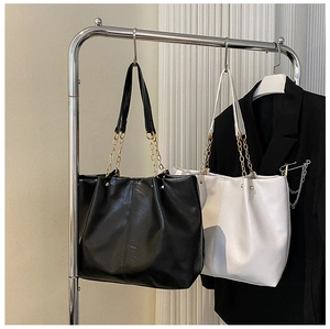 Détail de grands sacs fourre-tout noir et blanc avec chaînes en métal et rivets