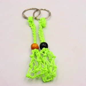 Detail of handmade neon green woven net keychain with wood beads and metal ring