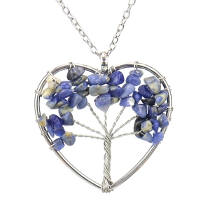 Close-up of handmade heart-shaped Tree of Life necklace with blue crystal stones