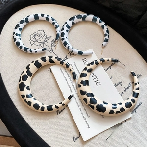 Detailed view of large C-shaped resin earrings with black leopard print spots