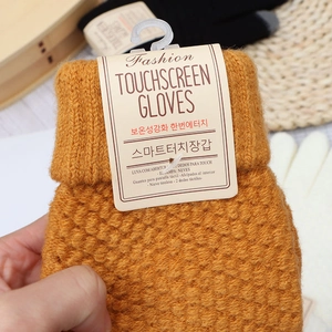 Detail shot of ginger knit touchscreen gloves with thick texture and product tags