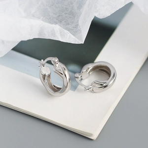 Macro shot of S925 sterling silver crossover hoop earrings with 925 authenticity stamp