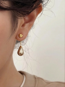 Close-up of French vintage waterdrop pearl earrings on model with hammered metal texture