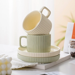 Minimalist ceramic coffee cup and saucer set with vertical striped texture in beige and green