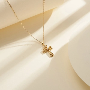 Close-up of golden Celtic knot cross pendant with a sparkling zircon on a link chain