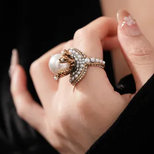 Vintage gold ring featuring a large white pearl and heart-shaped micro-pearl accents