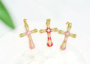 Macro view of 18K gold plated cross pendants with pink enamel and turquoise inlay