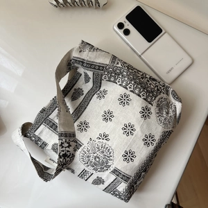 Detail of black paisley print cotton linen shoulder bag with wide strap and minimalist style