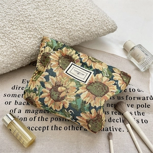 Detail of sunflower jacquard makeup bag with Pleasant Time label and cosmetic accessories